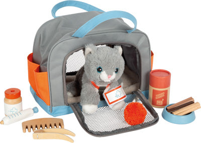 Katze mit Tasche und Pflege-Set: Enthält eine graue Plüschkatze in einer Tragetasche sowie Bürste, Kamm, Leckerlis und Ball – alles griffbereit außen arrangiert.